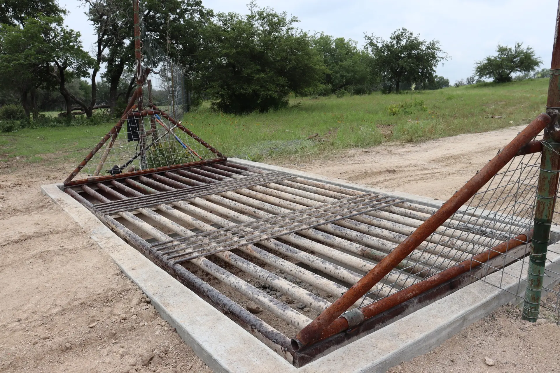 Heavy-duty steel cattle guard installed on a Texas Hill Country property